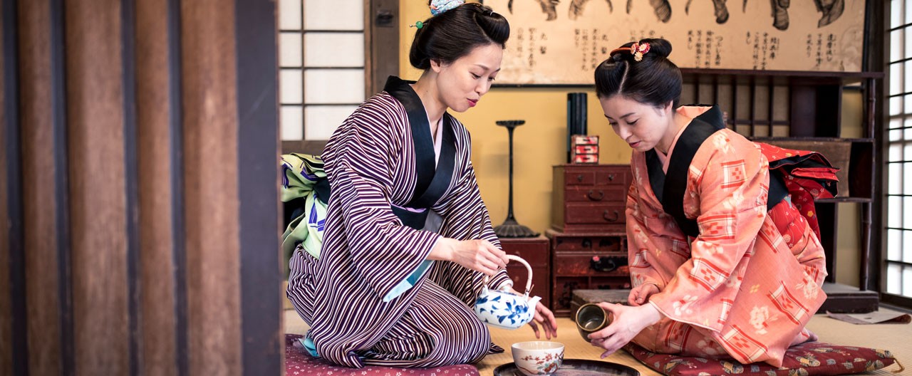 Two women wearing kimono sharing tea